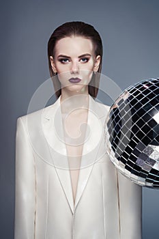 Studio fashion photo of young elegant woman in white men`s jacket