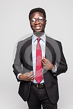 Studio fashion portrait of a handsome young African American businessman wearing a black suit and tie. Isolated on gray background