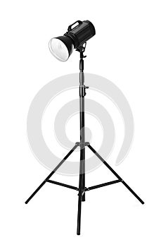 Studio flash light on tripod against white background. Professional photographer`s equipment