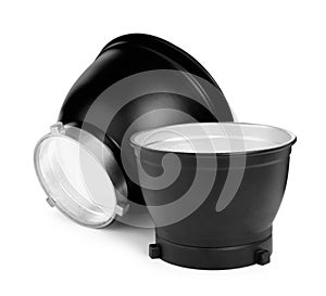 Studio flash lights reflectors on white background. Professional photographer`s equipment