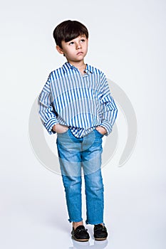 Studio full body portrait of a boy having serious worries