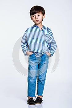 Studio full body portrait of a boy having serious worries