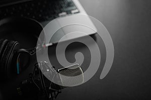 Studio headphones on a laptop and a studio microphone on a gray background. Low angle view. Radio, blogging, journalism,