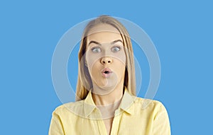 Studio headshot of young woman looking at something with funny surprised face expression