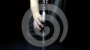 Studio image, close-up of male hand puts on lid for reusable, steel thermo water bottle on black background.