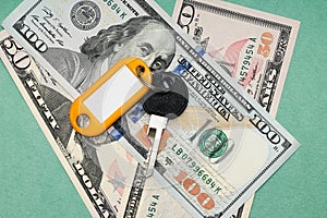 Studio image of keys and dollars on a green background