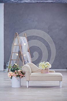 Studio interier decoration with flowers in light warm colors and casual vintage furniture