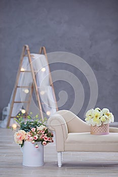 Studio interier decoration with flowers in light warm colors and casual vintage furniture