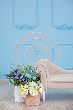 Studio interier decoration with flowers in light warm colors and casual vintage furniture