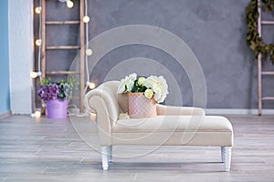 Studio interier decoration with flowers in light warm colors and casual vintage furniture