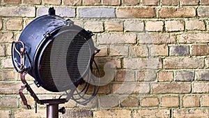 Studio lamp against the background of a brick wall. color