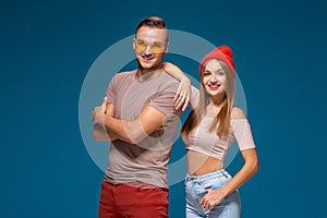 Studio lifestyle portrait of two best friends hipster wearing stylish bright outfits, hats, denim shorts and glasses