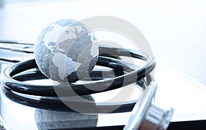 Studio macro of a stethoscope and texture globe