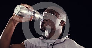 Studio, man or athlete drinking water on break after exercise, workout or fitness training for wellness. Black