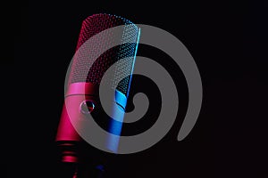 Studio microphone on dark background with neon lights