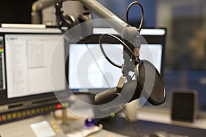 Studio microphone in front of radio station broadcasting equipment