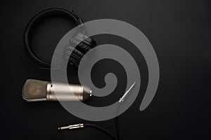 Studio microphone with headphones on a black background.Flat lay.Concept Radio, broadcasting, blog, studio, vocal, dikror