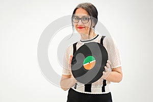 Studio photo of middle aged woman starting getting grey-haired wearing black and white clothes with vinyl record in