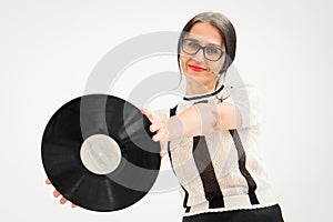 Studio photo of middle aged woman starting getting grey-haired wearing black and white clothes with vinyl record in