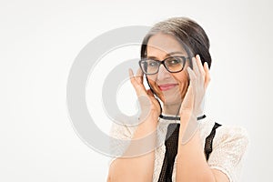 Studio photo of middle aged woman starting getting grey-haired wearing black and white clothes on white background