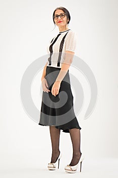 Studio photo of middle aged woman starting getting grey-haired wearing black and white clothes on white background