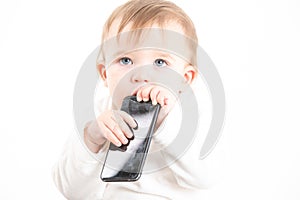 Studio photo with the white background of a baby\'s face with a mobile in his hands