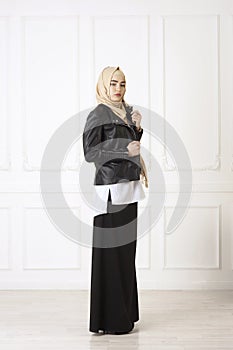 Studio photo of a young woman eastern type of clothing that combines modern and Muslim style, and a beautiful headdress