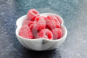 A Studio Photograph of Raspberries in a White Bowl