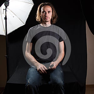 Studio photosession process. Man on black background