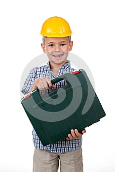 Studio picture of a young happy future builder in a beautiful blue checkred shirt and yellow helmet, holding toolbox photo