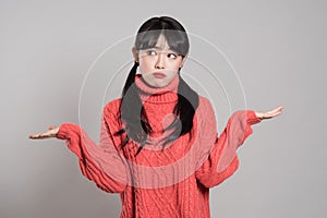 Studio portrait of 20 year old female Asian woman with both hands in absurd situation