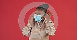 Studio portrait african american woman model wearing medical face styryl mask showing thumbs up like gesture of approval