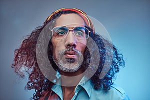 Studio portrait of African Rastafarian male wearing a blue shirt and beanie.