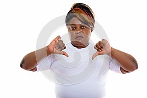 Studio shot of fat black African woman giving thumbs down ready