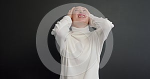 Studio portrait of annoyed bald woman in sweater gesturing in stress screaming