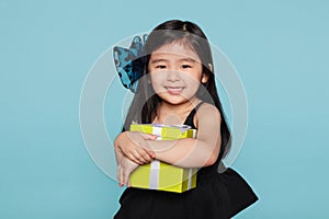 Studio portrait of asian girl happily receiving a gift