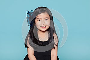 Studio portrait of asian girl with happy look in front of blue background