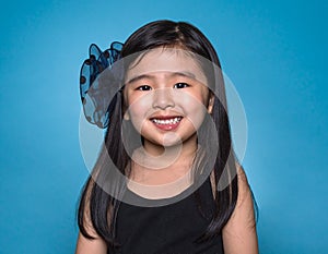 Studio portrait of asian girl with happy look in front of blue background