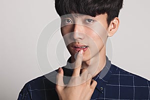 A studio portrait of an Asian young man smiling with a bright smile