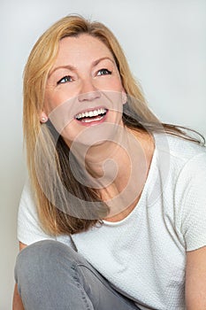 Studio portrait of an attractive happy middle aged blond woman in her forties