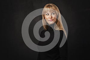 Studio portrait of an attractive middle age woman against dark background