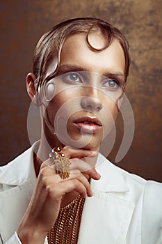 Studio portrait of attractive woman with gold make-up and wet ha