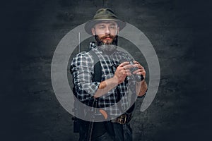 Bearded hunter holds a rifle.