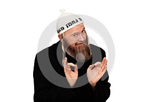 Studio portrait of bearded orthodox jewish man. Cheerful smiling charismatic jew with sidelocks in white yarmulke