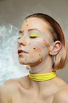 Studio portrait of beautiful girl with creative bright yellow makeup