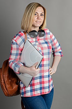 Studio portrait of a beautiful student girl or businesswoman holding laptop computer
