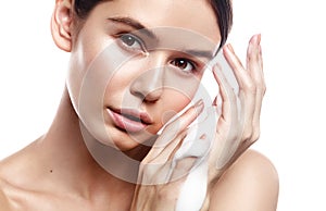 Studio portrait of beautiful woman cleans skin with foam on whit