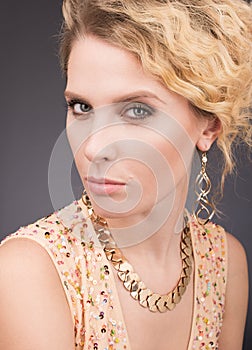 Studio portrait of beautiful woman with professional makeup and golden hair