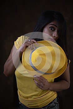 Studio portrait of a beautiful and young Indian Bengali female model in yellow tee shirt and jeans hot pat