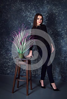 Studio portrait of beautiful young smiling woman wearing blue jeans and denim jacket